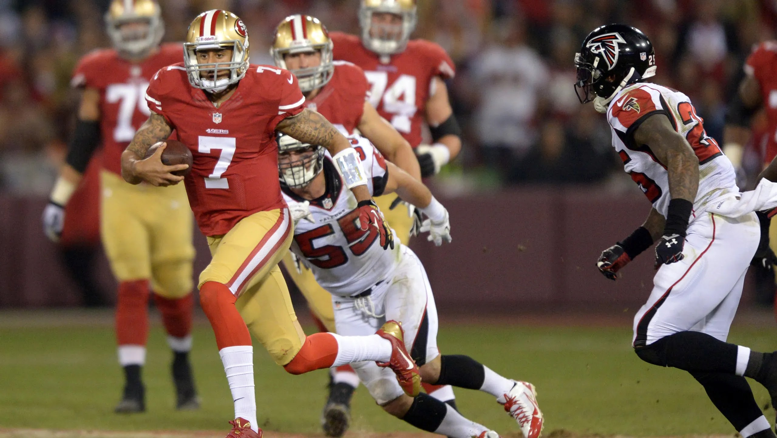 El quarterback de los San Francisco 49ers, Colin Kaepernick, lucha contra el linebacker, Colin Kaepernick, y el safety de los Atlanta Falcons, William Moore, en el último partido de la temporada regular en Candlestick Park. Fotografía: KIRBY LEE, EE.UU. USA TODAY
